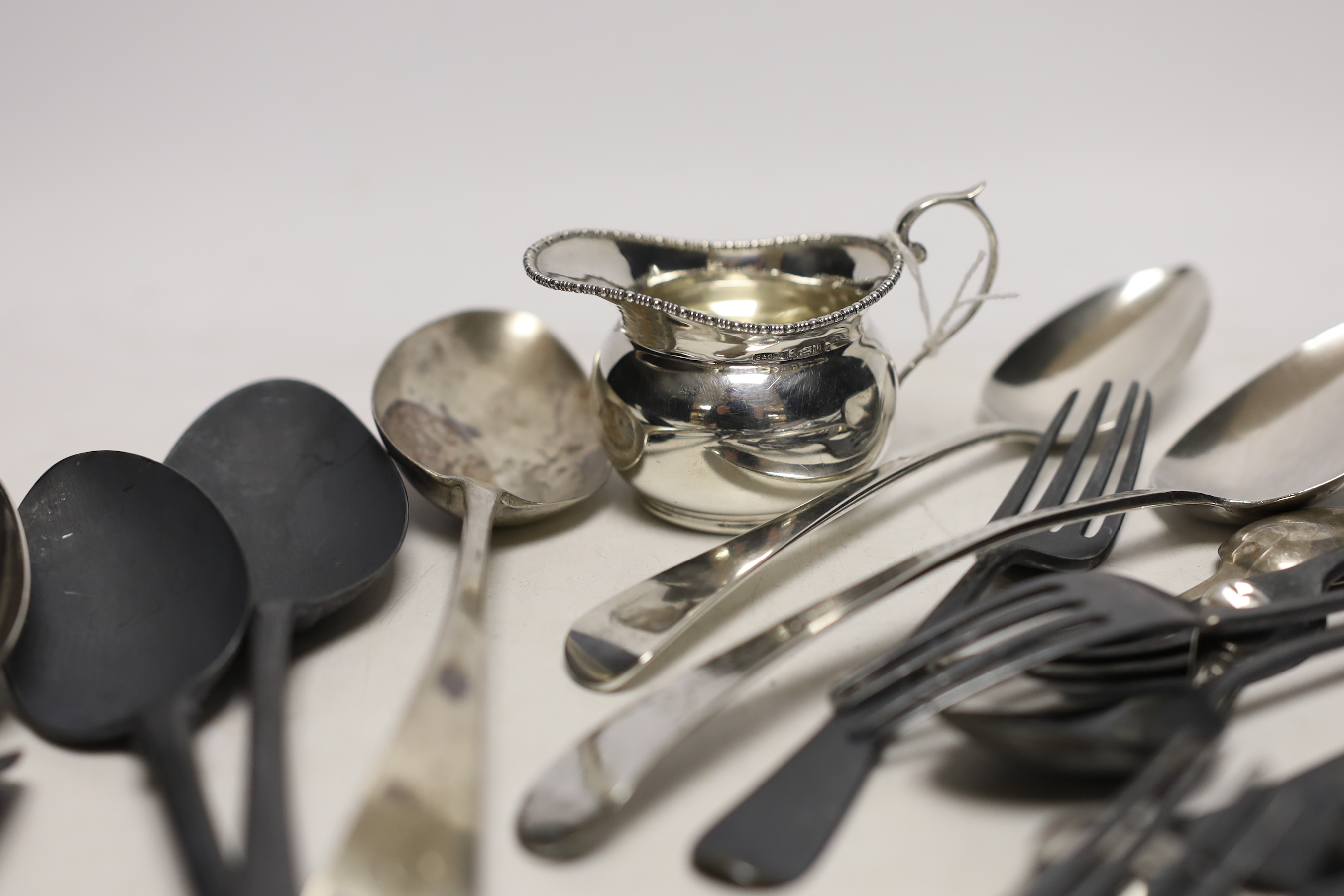 Twenty two assorted items of mainly 19th century flatware, various patterns, dates and makers, together with a small silver cream jug, 25.4oz.